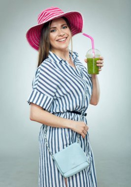 Çizgili elbise ve gree içme yaz şapka giyen gülümseyen kadın
