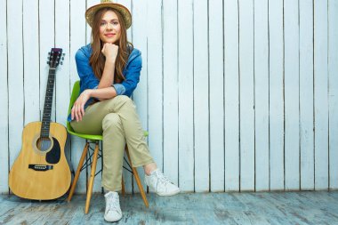 Gülümseyen gitar oturan kadın