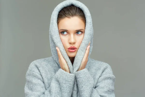 Young woman wearing coat hood sirprising. — Stock Photo, Image