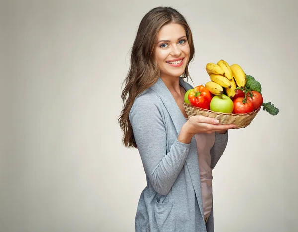 Mujer sosteniendo canasta de mimbre con frutas —  Fotos de Stock