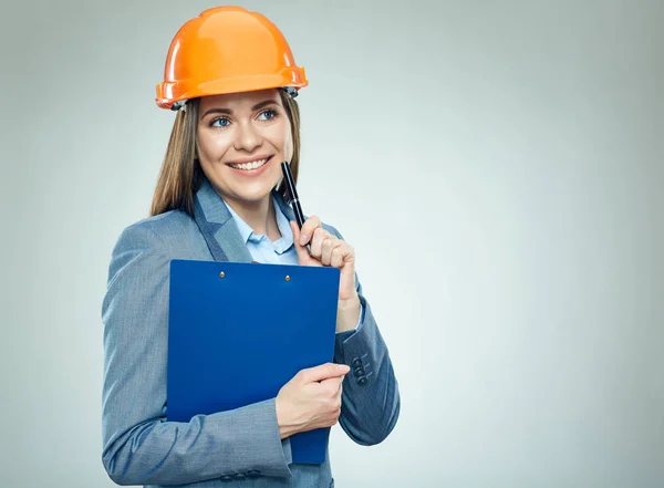 Pensando en la mujer de negocios constructora sosteniendo portapapeles — Foto de Stock