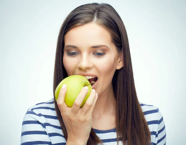 Mujer con aparatos dentales mordiendo manzana — Foto de Stock