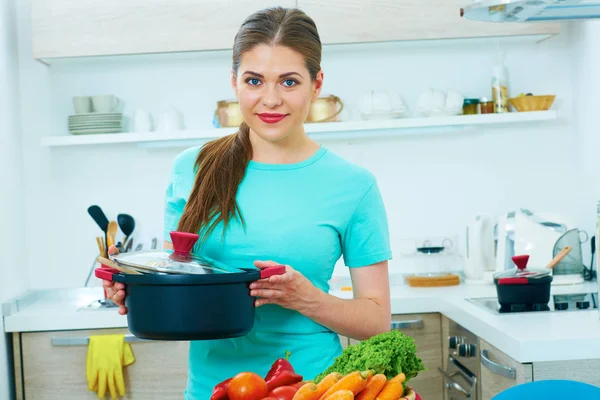 Femme souriante tenant casserole — Photo