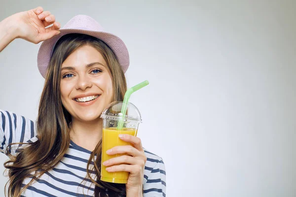 Młoda kobieta uśmiechający się trzymając soku pomarańczowego szkła. — Zdjęcie stockowe