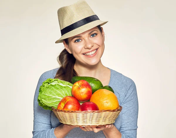 Улыбающаяся женщина держит корзину с фруктами и овощами . — стоковое фото