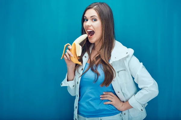 Young woman eat banana in order to feel happy.
