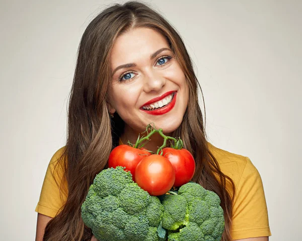 Lachende vrouw geïsoleerde portret met tomaten en broccoli. — Stockfoto