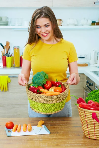 Mujer sosteniendo cesta de mimbre con verduras —  Fotos de Stock