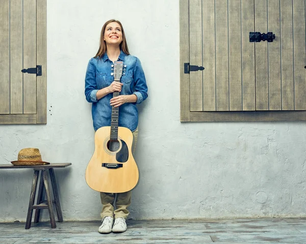 tuğla duvara yaslanmış gitar kadınla 