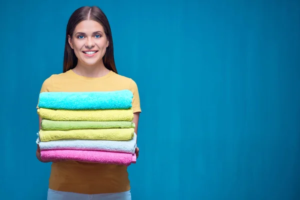 Uśmiechnięta kobieta trzyma stos ręczników. — Zdjęcie stockowe