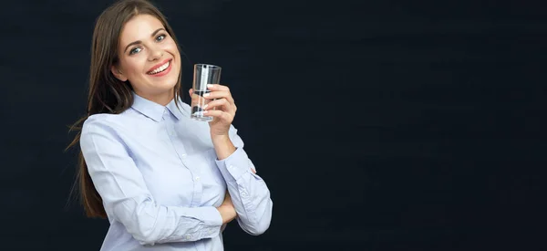 Mujer sonriente con cabello largo sosteniendo un vaso de agua . — Foto de Stock