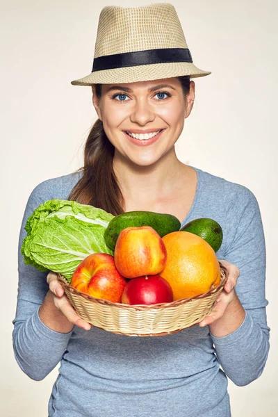 Usmívající se žena hospodářství košík s ovocem a zeleninou. — Stock fotografie