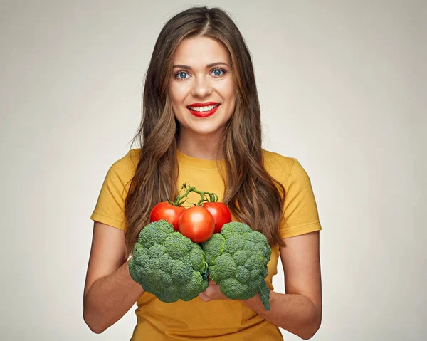 Жінка тримає помідори і брокколі — стокове фото