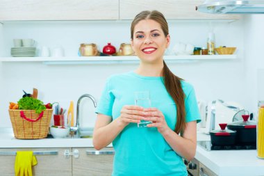 su cam tutarak ve mutfakta ayakta güzel genç kadın