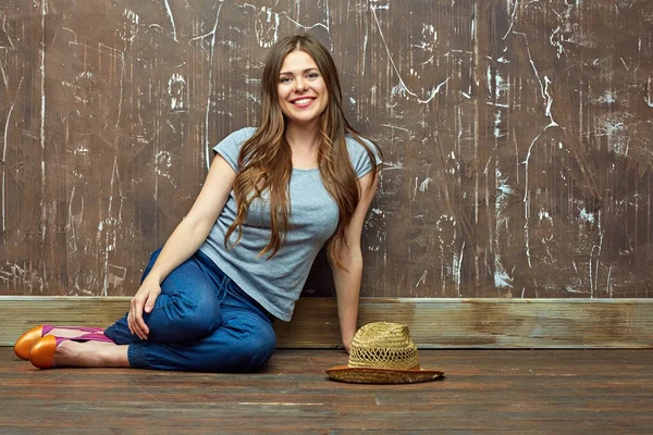 Gülümseyen Kadın Grunge Arka Plan Duvar Katta Oturan Rahat Giyinmiş — Stok fotoğraf