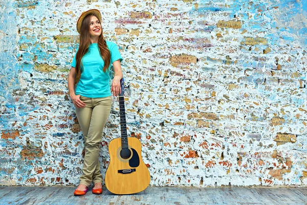 Уличная Фотография Улыбающейся Молодой Женщины Гитарой Стоящей Кирпичной Стены — стоковое фото