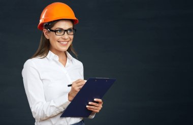 Pano siyah arka plan üzerine yazma turuncu koruyucu kask içinde gülümseyen kadın