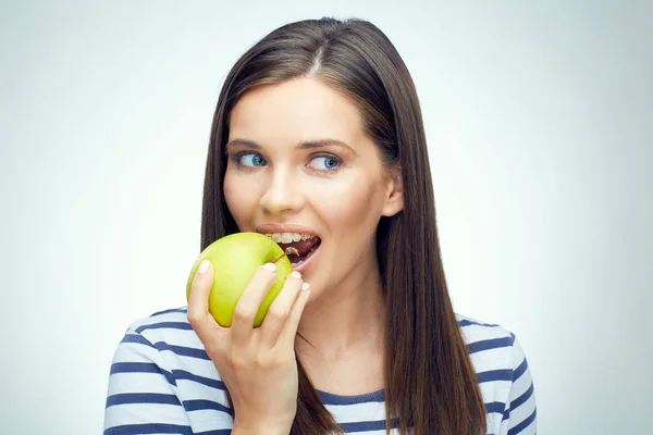 Woman with dental braces biting apple — Stock Photo, Image