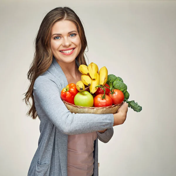 Kvinna som innehar korg med frukt och grönsaker — Stockfoto