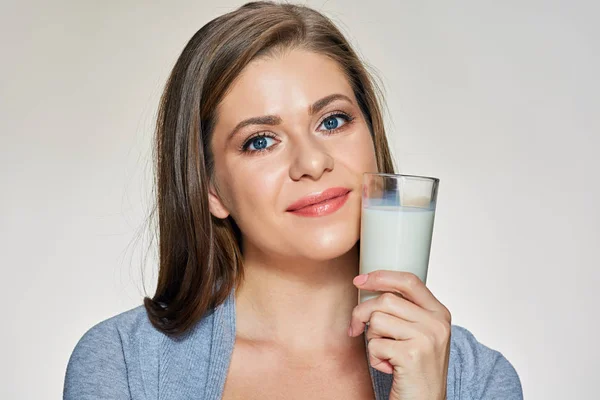 Retrato de cerca de la cara de una mujer joven sosteniendo un vaso de leche . —  Fotos de Stock