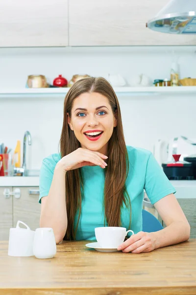 Glimlachend jonge vrouw drinken koffie in keuken. — Stockfoto