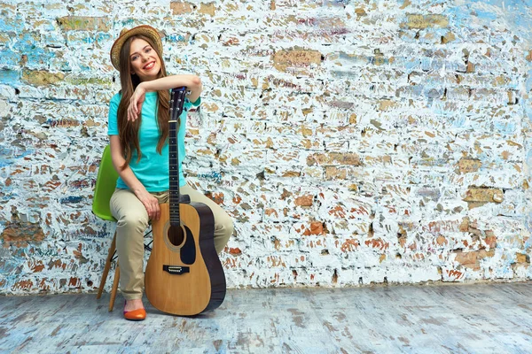 Sorrindo jovem mulher sentada com guitarra — Fotografia de Stock