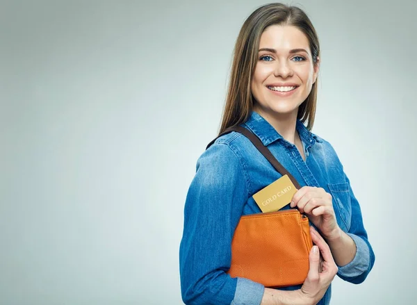 Smiling girl takes out gold credit card from handbag. — Stock Photo, Image