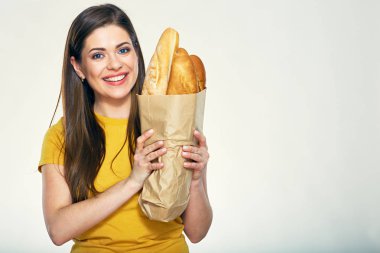 Kağıt alışveriş çantası ekmek ile tutan gülümseyen kadın.
