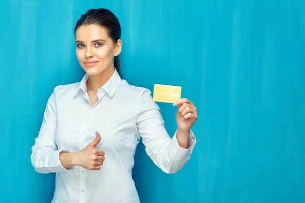 Smiling businesswoman holding credit card shows thumb up.