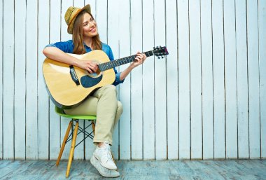 Gülümseyen genç kadın gitar dolaşan