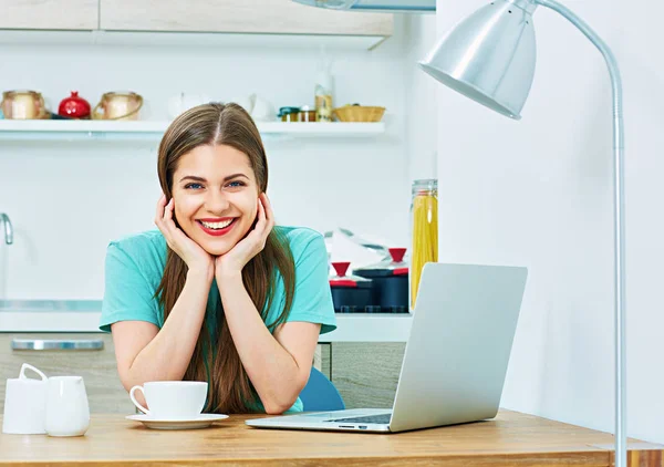 Uśmiechnięta kobieta w kuchni z laptopa. — Zdjęcie stockowe