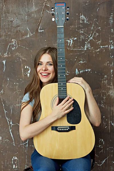 Улыбающаяся женщина с гитарой — стоковое фото