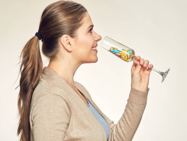 gülümseyen kadın vitamin hapları içki bardağı, sağlıklı yaşam kavramı 