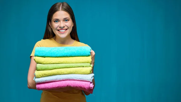 Mujer Sonriente Sosteniendo Pila Toallas Colores Sobre Fondo Estudio Azul —  Fotos de Stock
