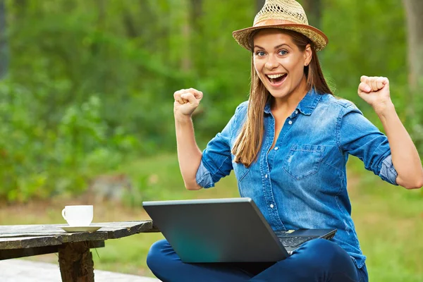 Vrouw met laptop in tuin — Stockfoto