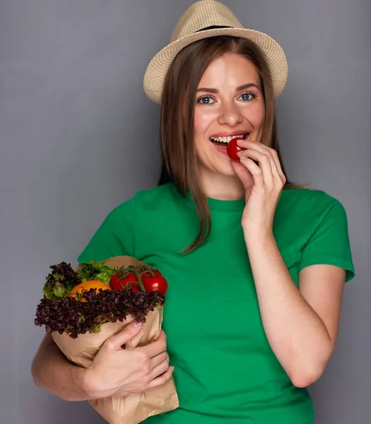 Молода жінка тримає паперовий мішок з овочами — стокове фото