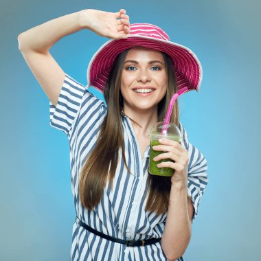 çizgili elbise ve cam yeşil Detoks güler yüzlü içki ile tutarak yaz şapka giyen gülümseyen kadın 