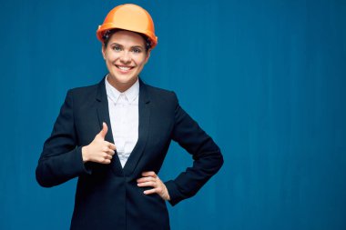 takım elbise ve başparmak gösterilmesini turuncu koruyucu kask gülümseyen iş kadını 