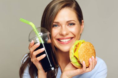 Burger cola cam ile ışık arka plan üzerinde tutan mutlu kadın 