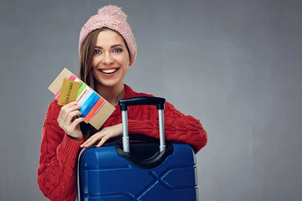 gülümseyen kadın çalışması ve pasaportu ile kredi kartı tutan kış giysileri içinde kış tatil seyahat kavramı 