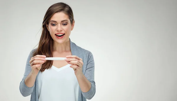 Smiling young woman holding white pregnant test. — Stock Photo, Image