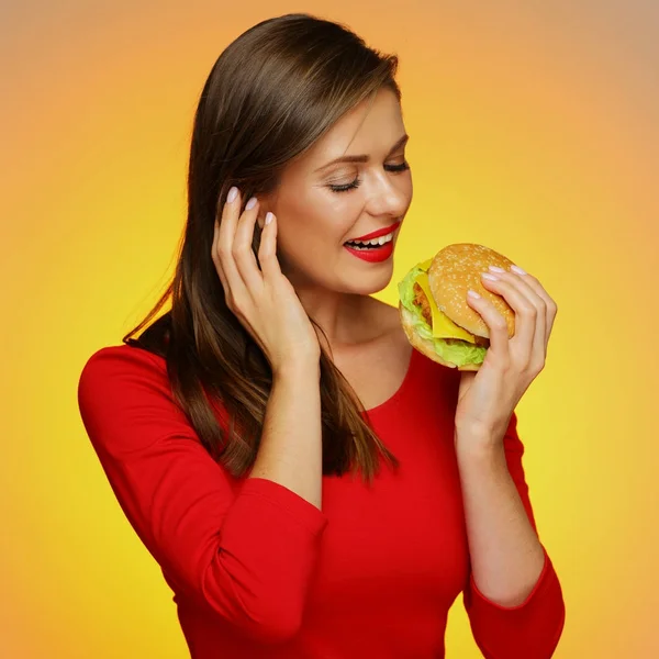 Gelukkige Vrouw Rode Jurk Bijten Hamburger Gele Achtergrond — Stockfoto