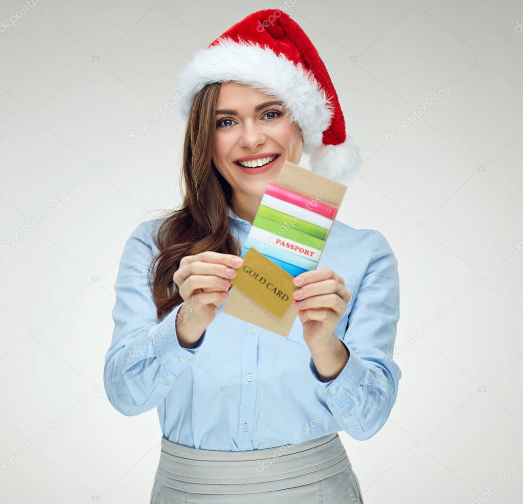 Smiling woman traveler wearing christmas hat holding passport, t