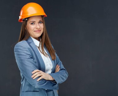 kadın Oluşturucusu mühendisi iş takım elbise gri duvar karşı çapraz kollar ile ayakta 