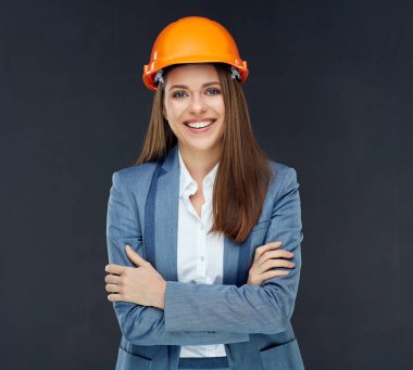 kadın Oluşturucusu mühendisi iş takım elbise gri duvar karşı çapraz kollar ile ayakta 