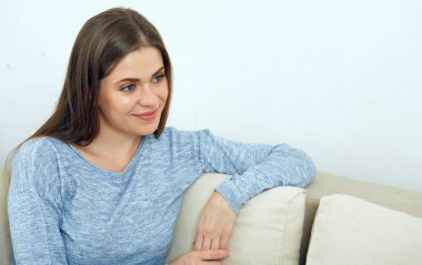 Mutlu gülümseyen kadın oturma odasında kanepede otururken rahatlatıcı 