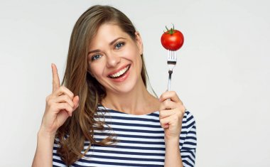 Kadın holding domates çatal, kavram diyet üzerinde gülümseyen