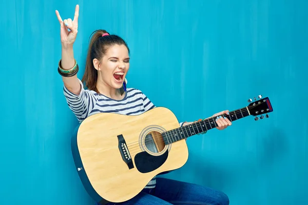 Atrakcyjna Kobieta Trzyma Gitarę Wyświetlono Rock Znak Siedząc Pobliżu Niebieską — Zdjęcie stockowe