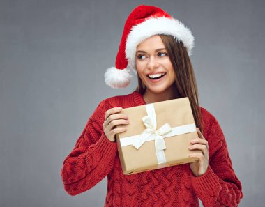 Holding kağıt hediye kutusu ve l kadın giyen Noel şapka gülümseyen