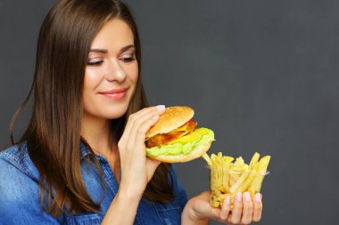 Burger patates ile tutan gülümseyen kadın patates kızartması